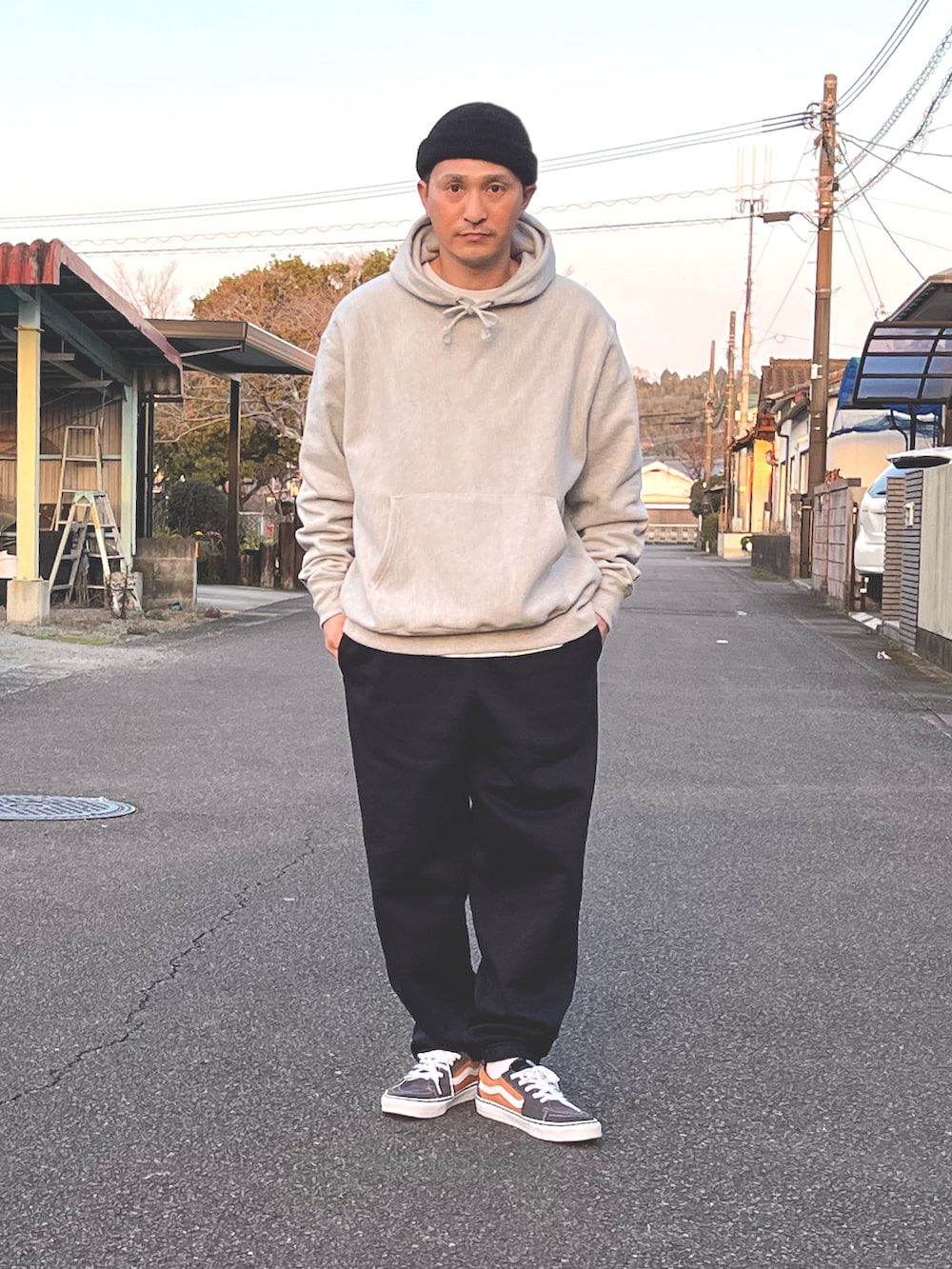 グレー系のパーカー、ブラック系のスウェットパンツ、オレンジ系のスニーカーを着用したメンズの春コーディネートの2枚目の写真