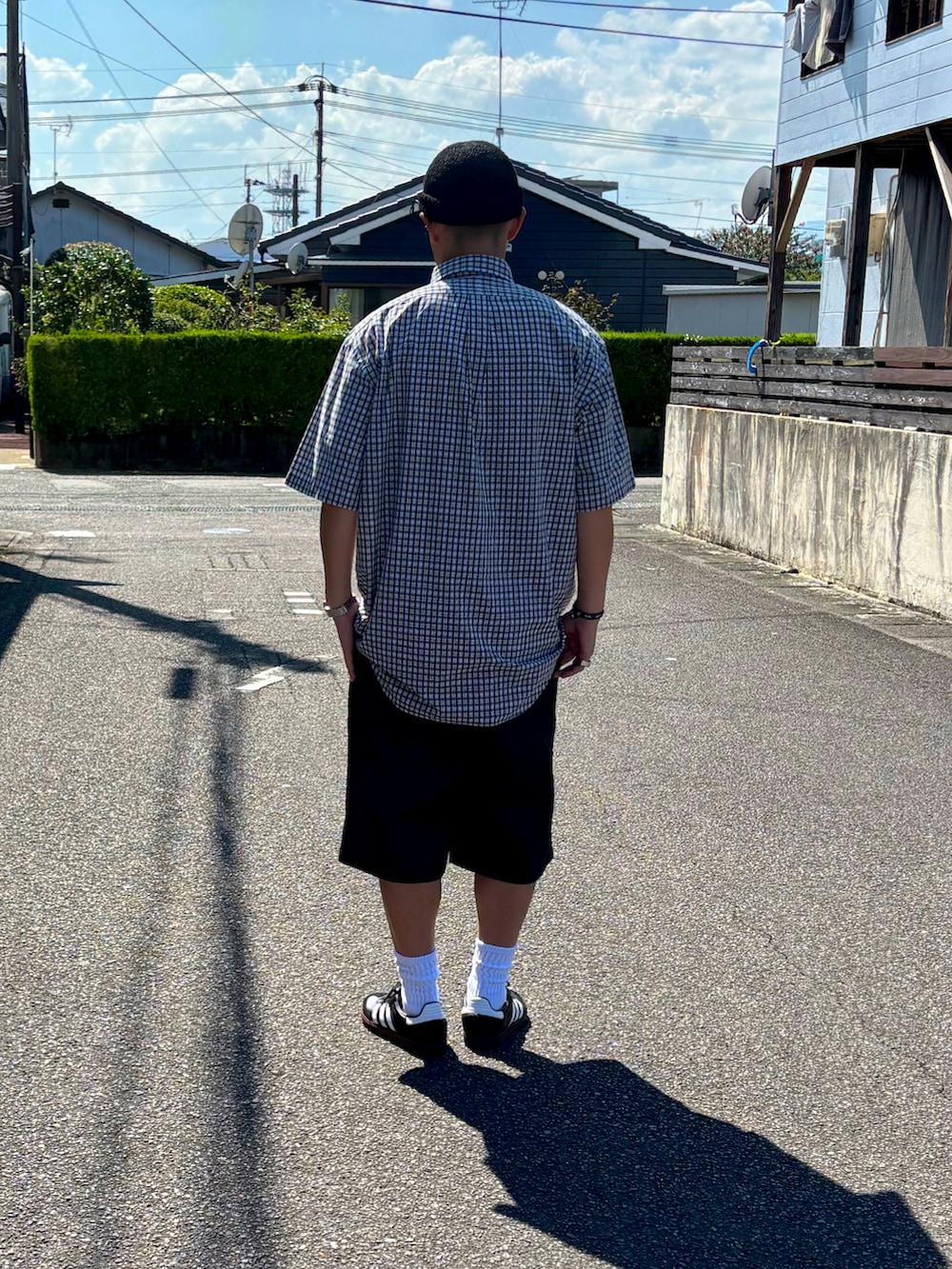 ホワイト系のTシャツ/カットソー、ブラック系のチノパンツ、ブラック系のスニーカーを着用したメンズの秋コーディネートの3枚目の写真