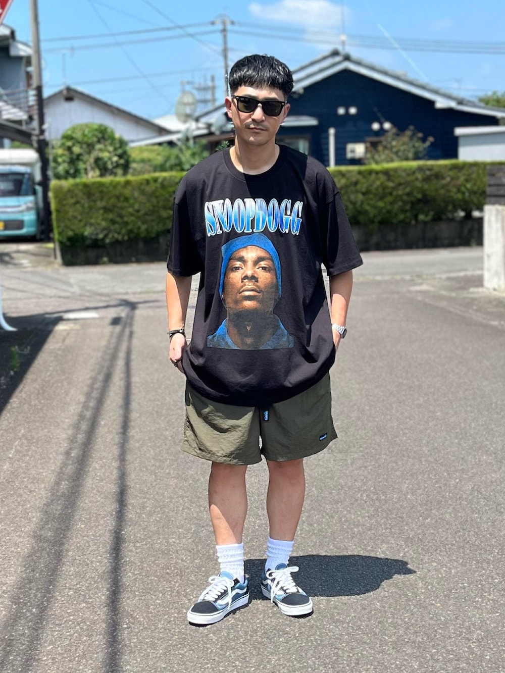 ブルー系のスニーカー、グリーン系のその他パンツ、ブラック系のTシャツ/カットソーを着用したメンズの夏コーディネートの2枚目の写真