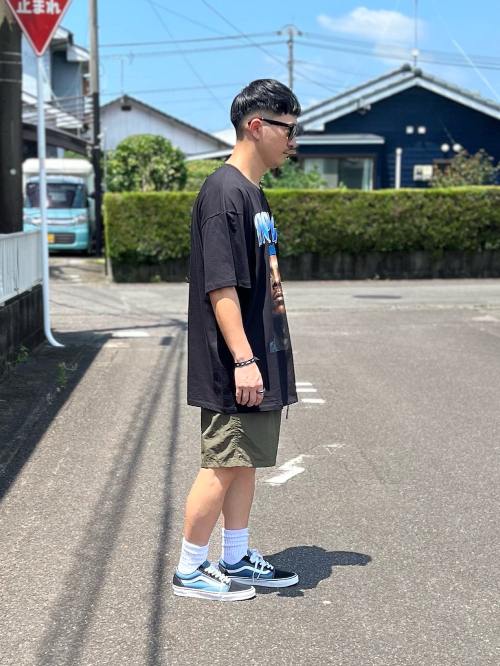 ブルー系のスニーカー、グリーン系のその他パンツ、ブラック系のTシャツ/カットソーを着用したメンズの夏コーディネートの3枚目の写真