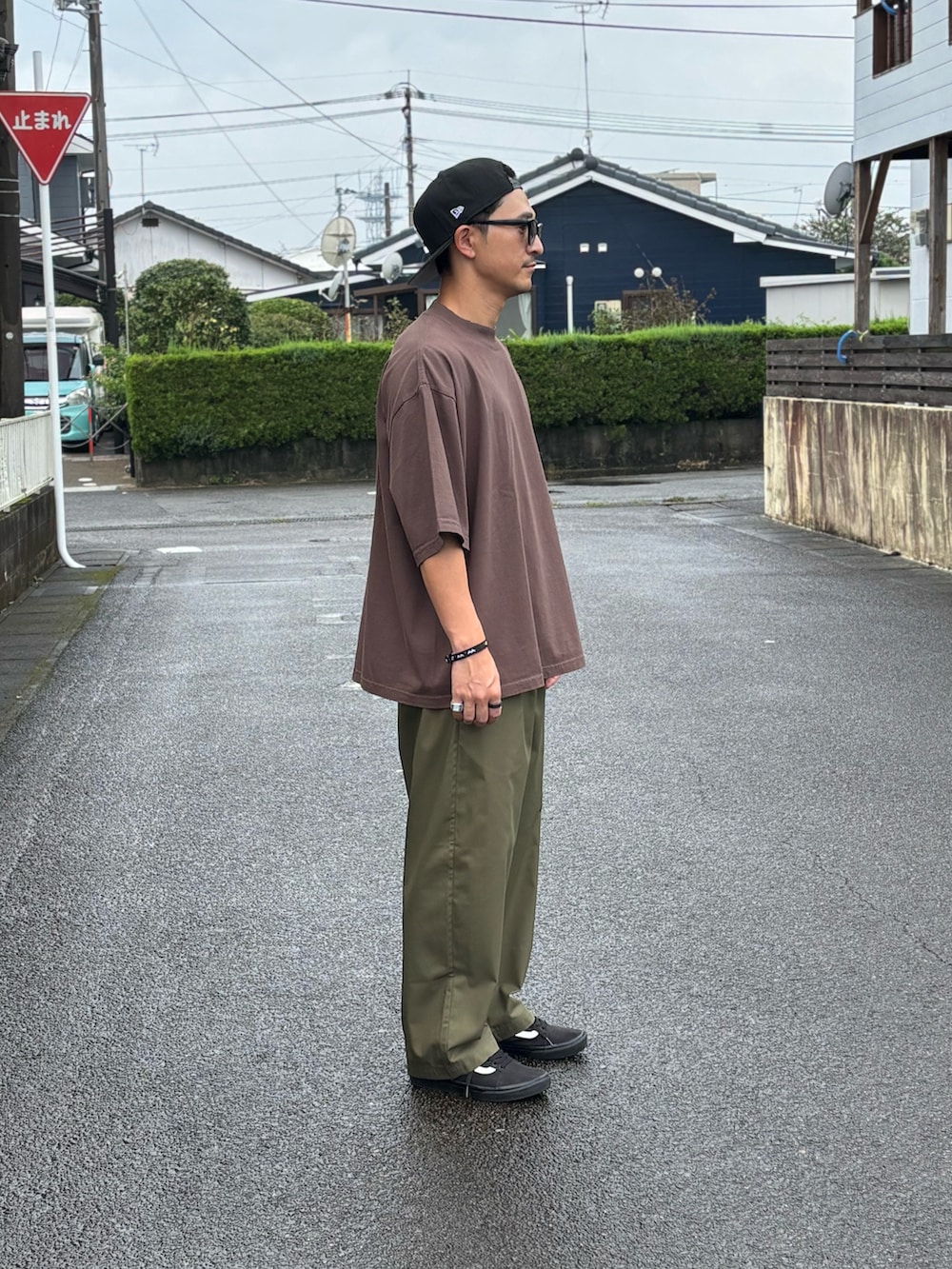ブラック系のTシャツ/カットソー、グリーン系のチノパンツ、ブラック系のスニーカーを着用したメンズの秋コーディネートの3枚目の写真