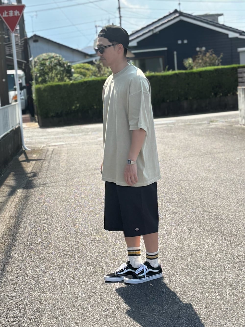 ブラック系のTシャツ/カットソー、ブラック系のチノパンツ、ブラック系のスニーカーを着用したメンズの秋コーディネートの2枚目の写真