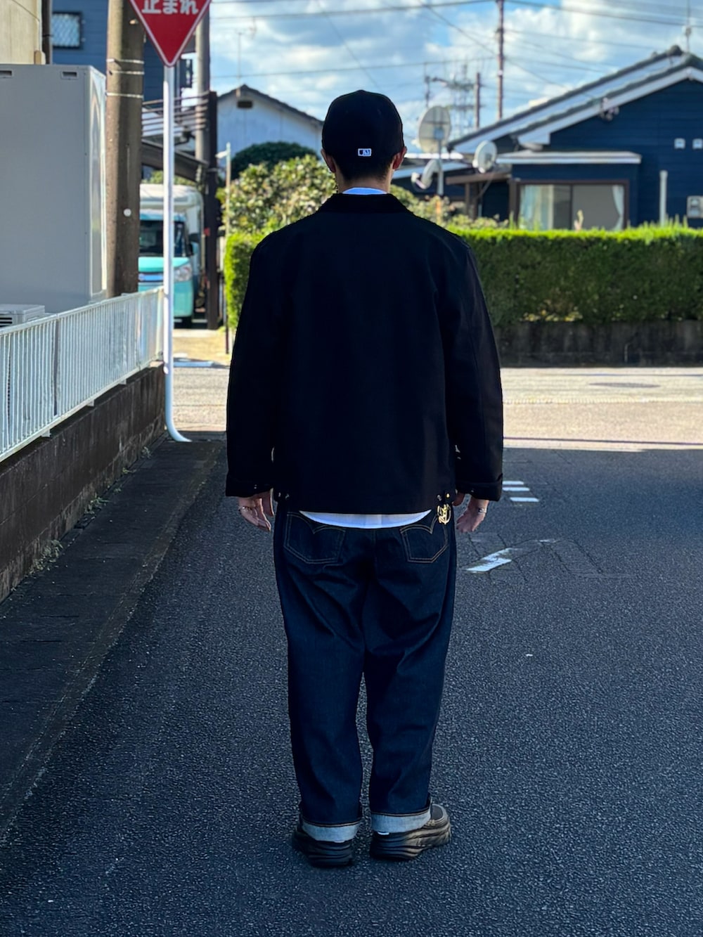 ブルー系のデニムパンツ、ブラック系のその他アウター、ブラック系のスニーカーを着用したメンズの冬コーディネートの3枚目の写真