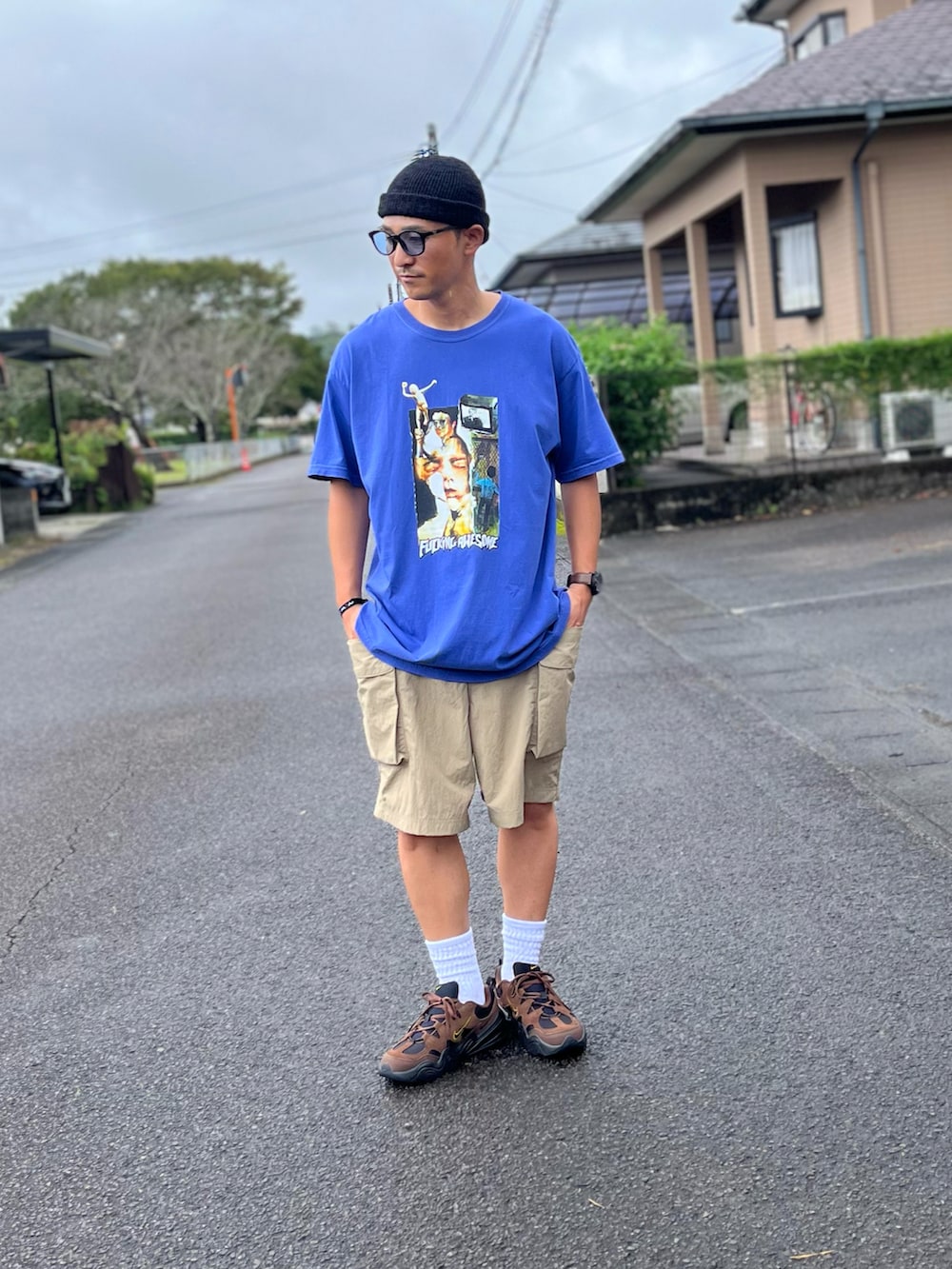 ブルー系のTシャツ/カットソー、ベージュ系のカーゴパンツ、ブラウン系のスニーカーを着用したメンズの秋コーディネートの2枚目の写真