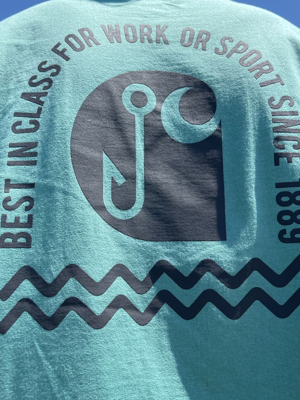 グリーン系のTシャツ/カットソー、グレー系のチノパンツ、ブラック系のスニーカーを着用したメンズの春コーディネートの4枚目の写真