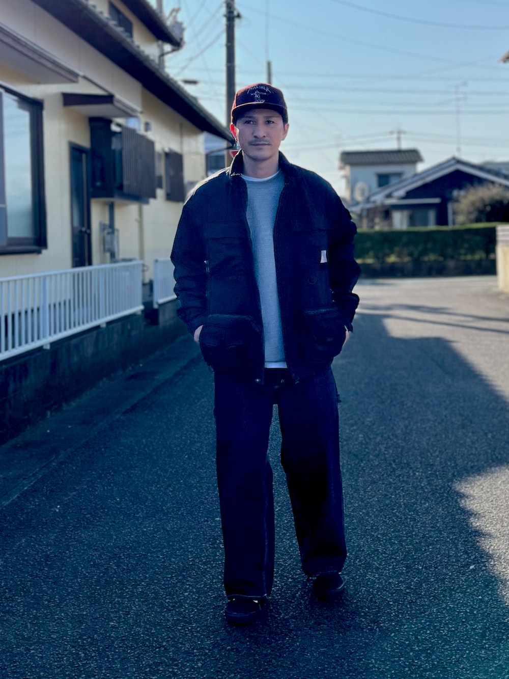 グレー系のスウェット、ブラック系のジャケット/アウター、ブルー系のデニムパンツを着用したメンズの冬コーディネートの3枚目の写真