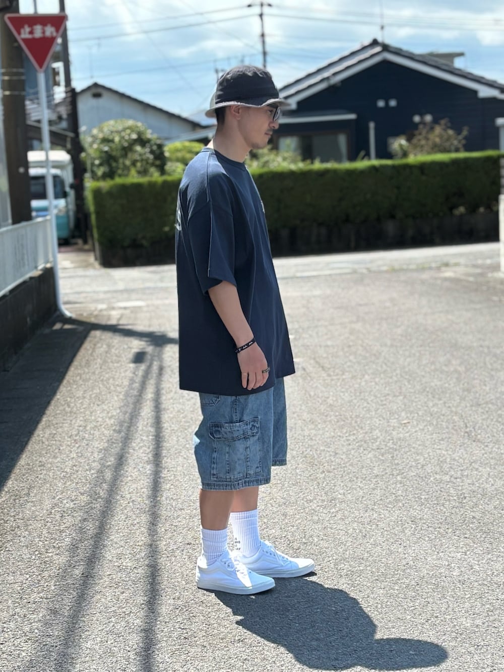 ブルー系のTシャツ/カットソー、ホワイト系のスニーカー、ブルー系のデニムパンツを着用したメンズの秋コーディネートの2枚目の写真
