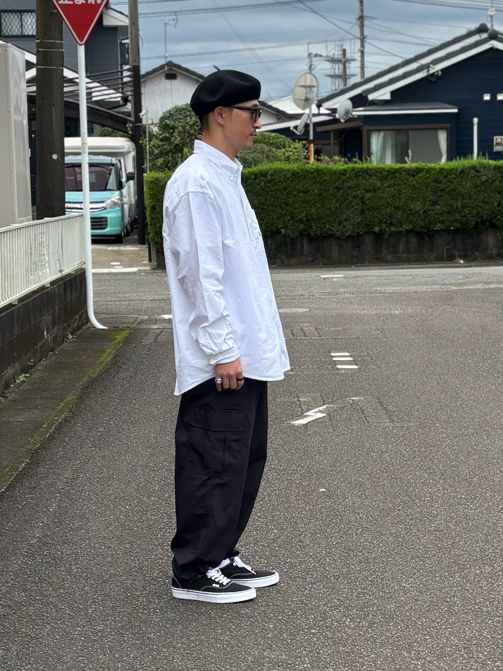 ブラック系のスニーカー、ホワイト系のシャツ/ブラウス、ベージュ系のカーゴパンツを着用したメンズの秋コーディネートの3枚目の写真
