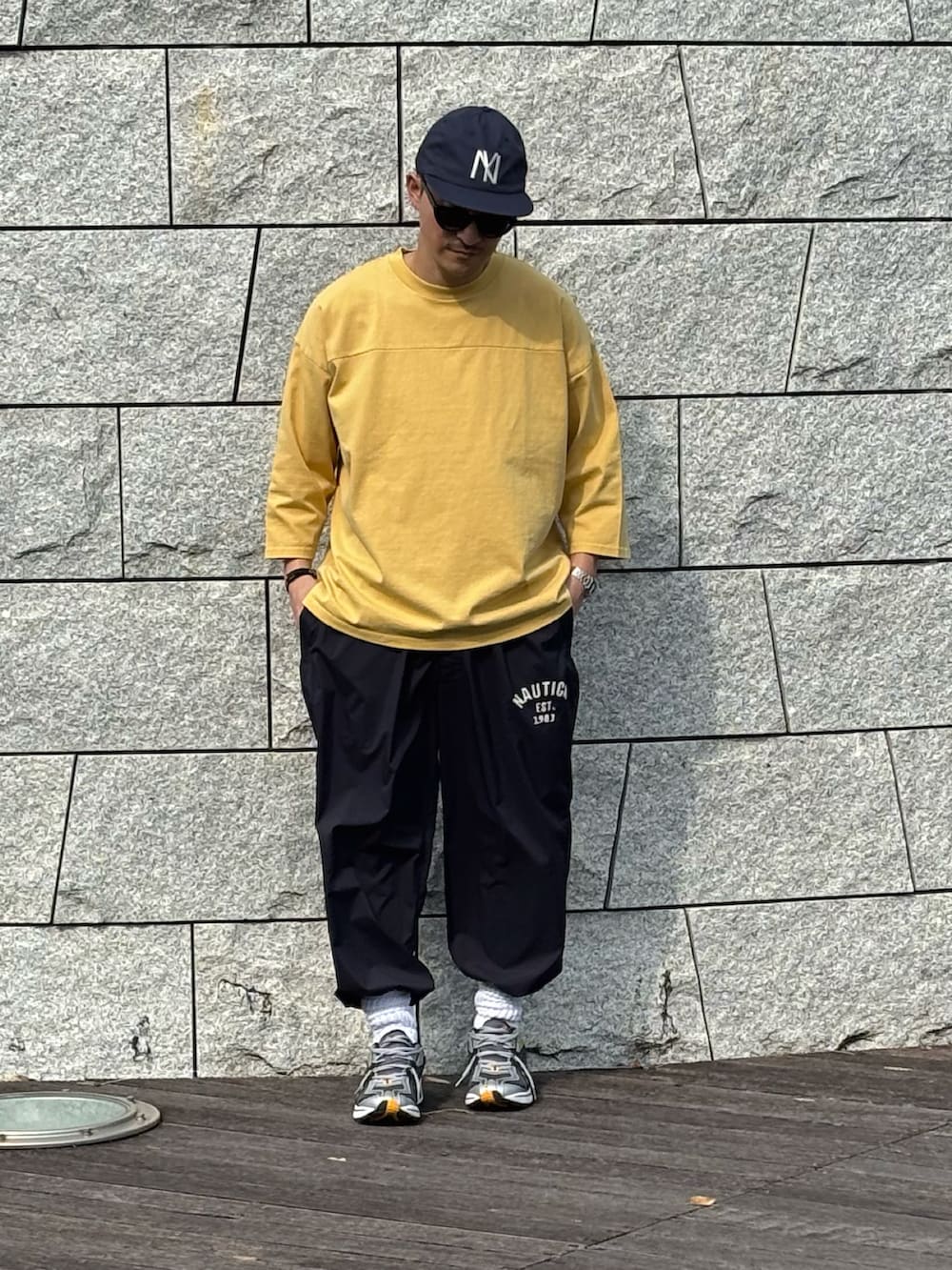 ブルー系のその他パンツ、イエロー系のTシャツ/カットソー、シルバー系のスニーカーを着用したメンズの春コーディネートの2枚目の写真
