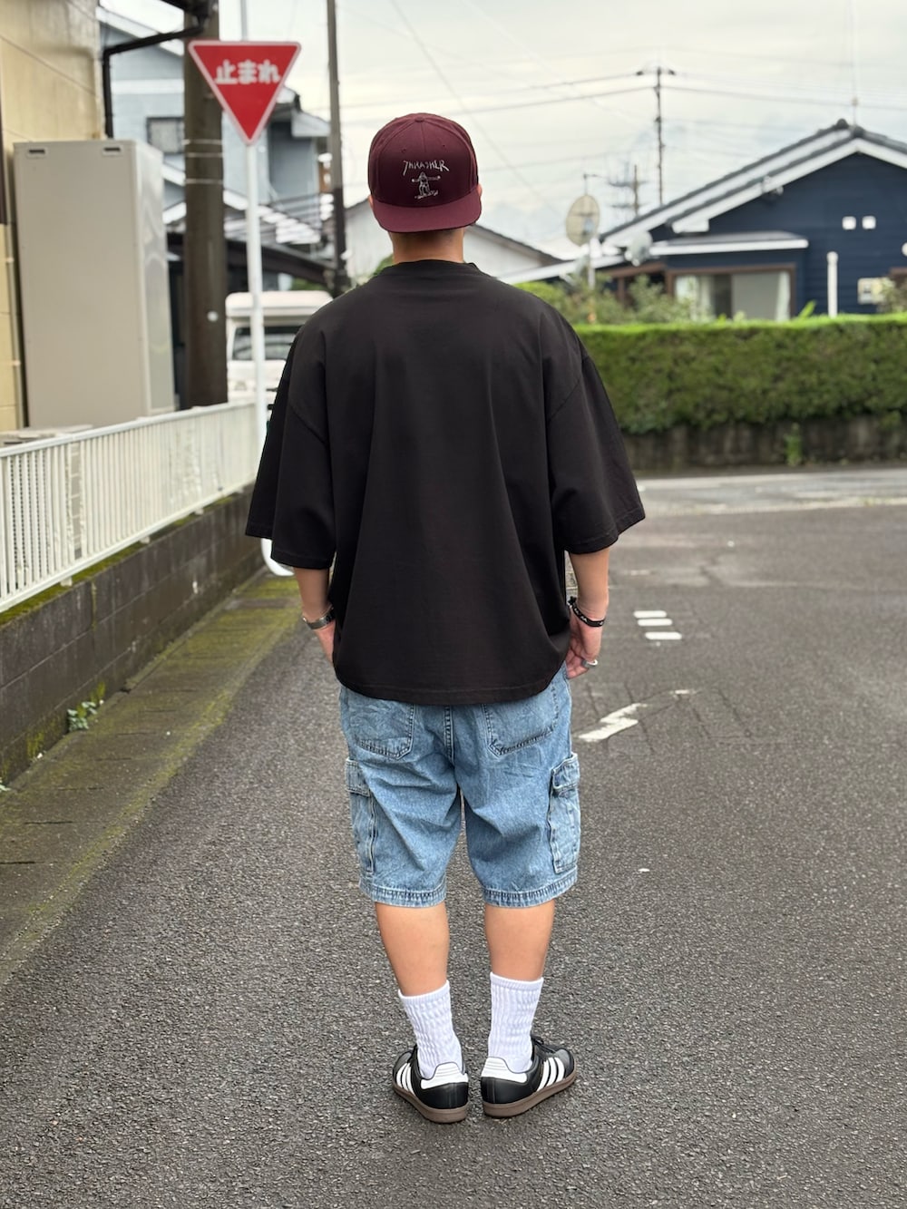 ブラック系のTシャツ/カットソー、ブラック系のスニーカー、ブルー系のデニムパンツを着用したメンズの夏コーディネートの3枚目の写真