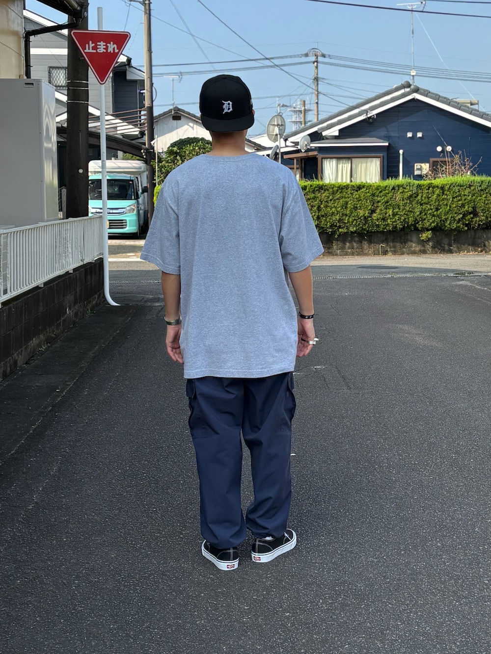 ブラック系のスニーカー、グレー系のTシャツ/カットソー、ベージュ系のカーゴパンツを着用したメンズの秋コーディネートの4枚目の写真