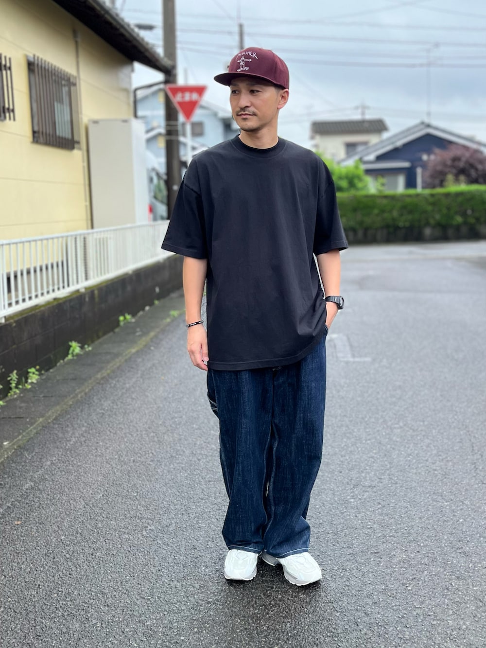 ブラック系のTシャツ/カットソー、ブルー系のデニムパンツ、グレー系のスニーカーを着用したメンズの春コーディネートの2枚目の写真