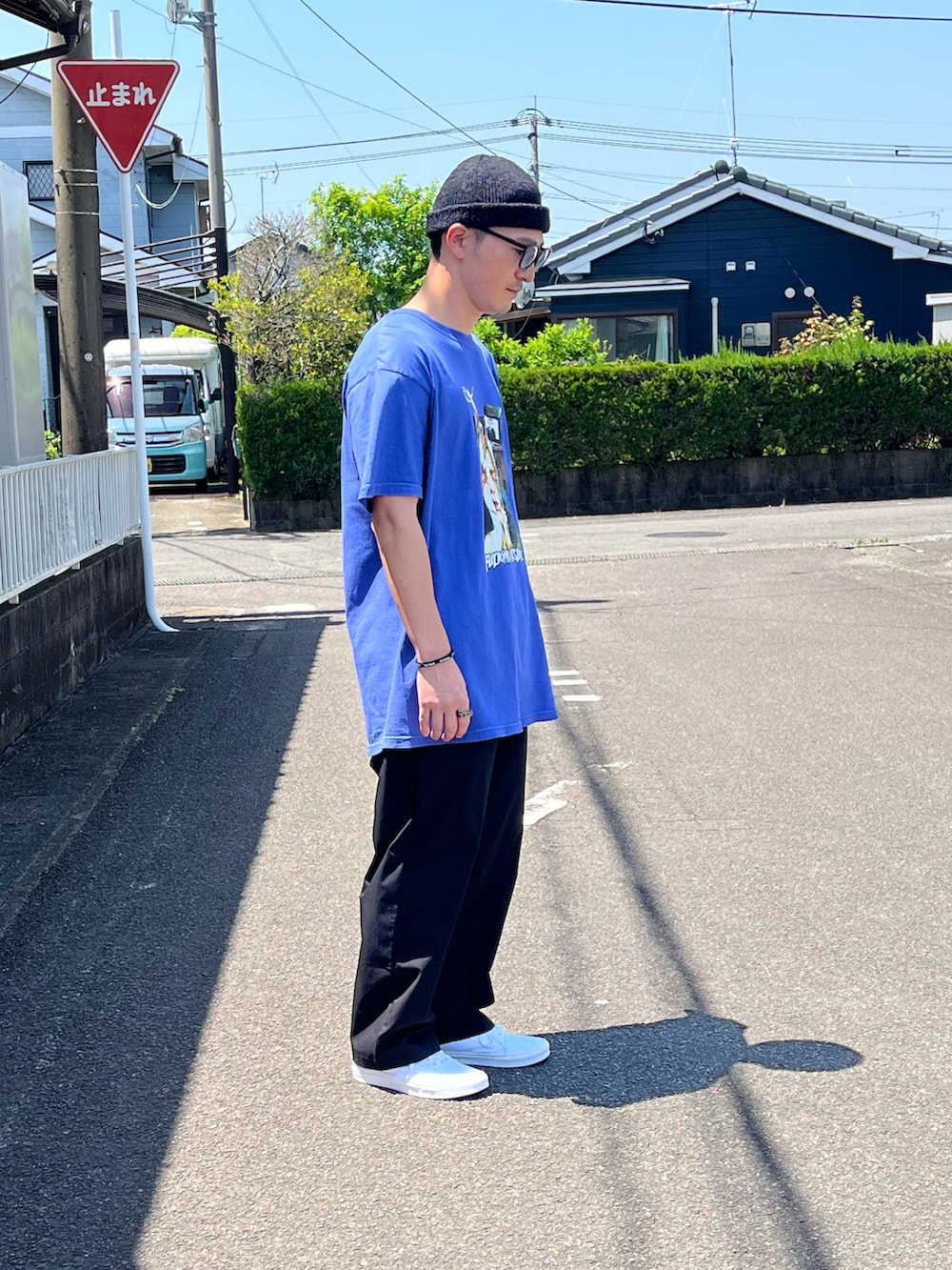 ブルー系のTシャツ/カットソー、ブラック系のパンツ、ホワイト系のスニーカーを着用したメンズの春コーディネートの2枚目の写真