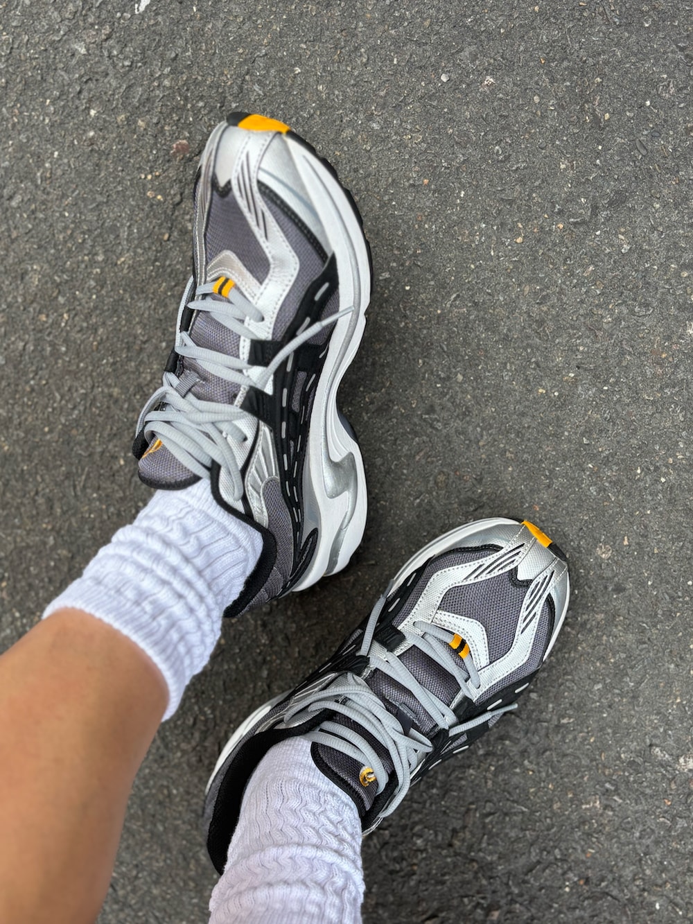 ブラック系のTシャツ/カットソー、イエロー系のパンツ、シルバー系のスニーカーを着用したメンズの秋コーディネートの3枚目の写真