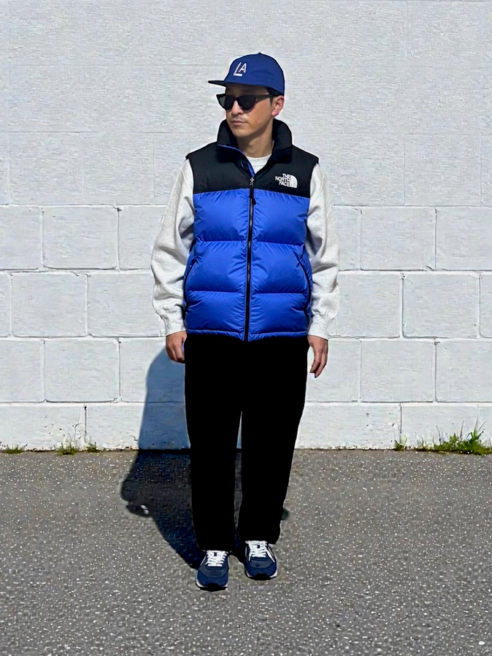 グレー系のスウェット、ブルー系のダウンベスト、グレー系のスウェットパンツを着用したメンズの冬コーディネートの2枚目の写真