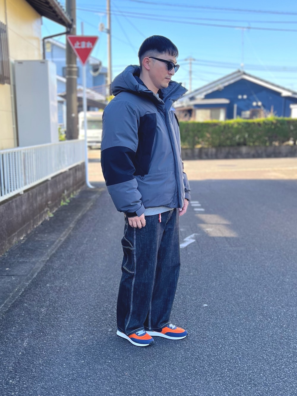 グレー系のダウンジャケット/コート、グレー系のスウェット、ブラック系のデニムパンツを着用したメンズの冬コーディネートの2枚目の写真