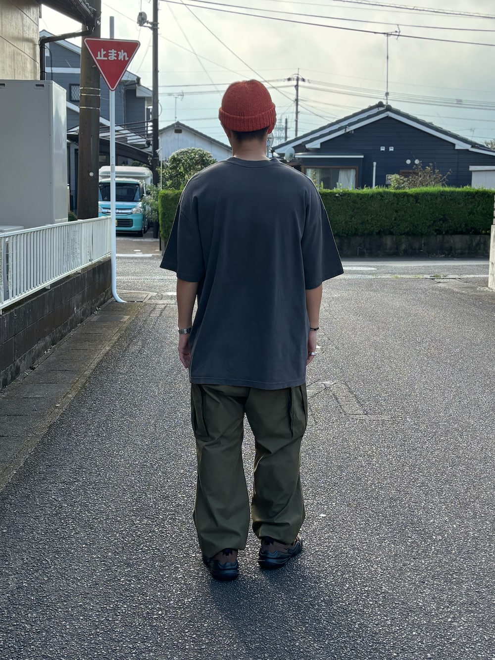 ブラック系のTシャツ/カットソー、グリーン系のカーゴパンツ、ブラウン系のスニーカーを着用したメンズの秋コーディネートの3枚目の写真