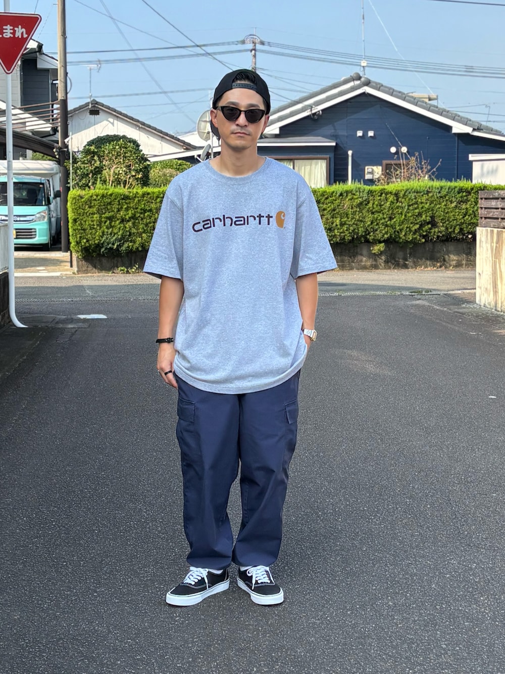 ブラック系のスニーカー、グレー系のTシャツ/カットソー、ベージュ系のカーゴパンツを着用したメンズの秋コーディネートの2枚目の写真