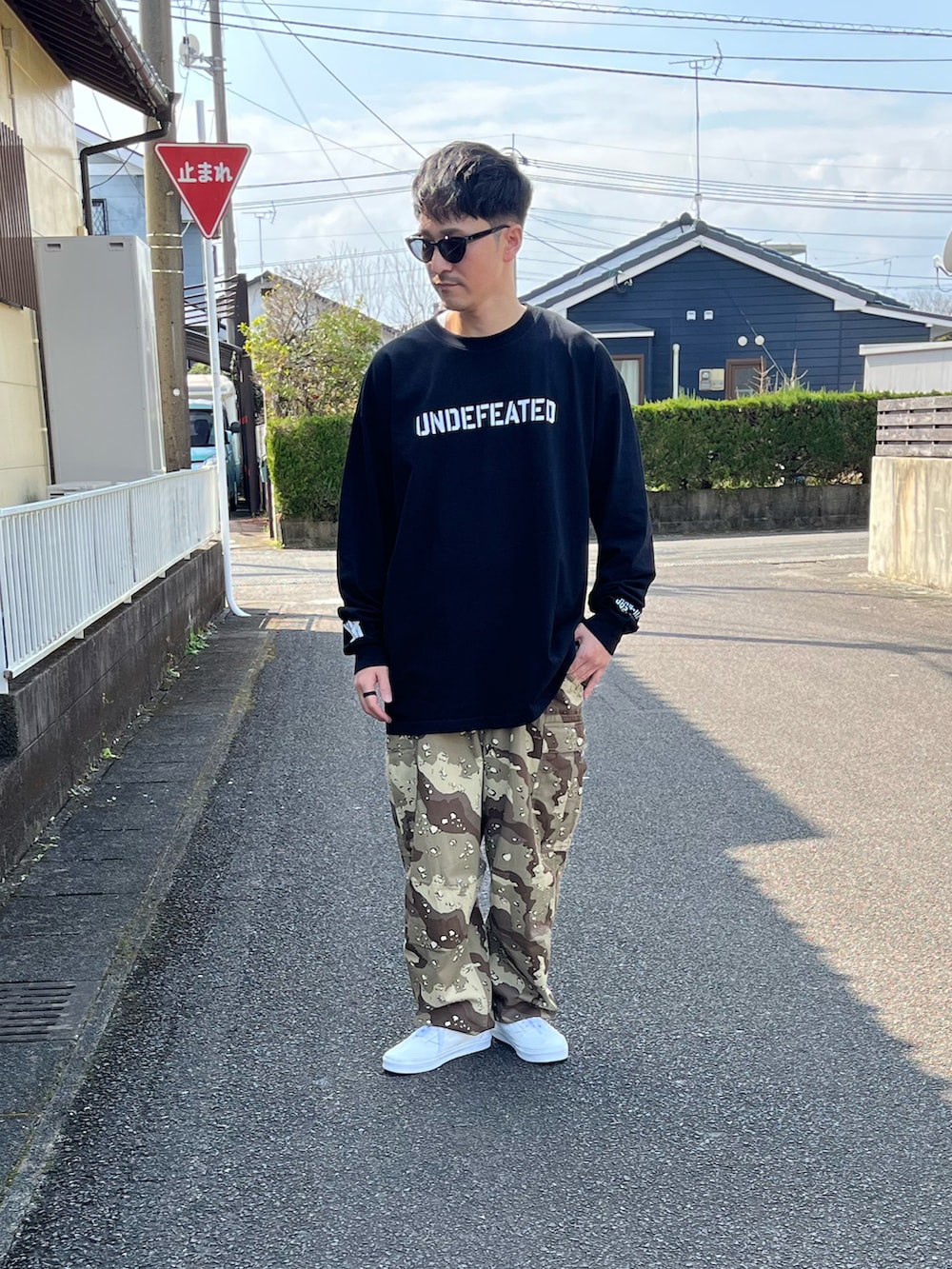 ブラック系のTシャツ/カットソー、ベージュ系のカーゴパンツ、ホワイト系のスニーカーを着用したメンズの春コーディネートの2枚目の写真