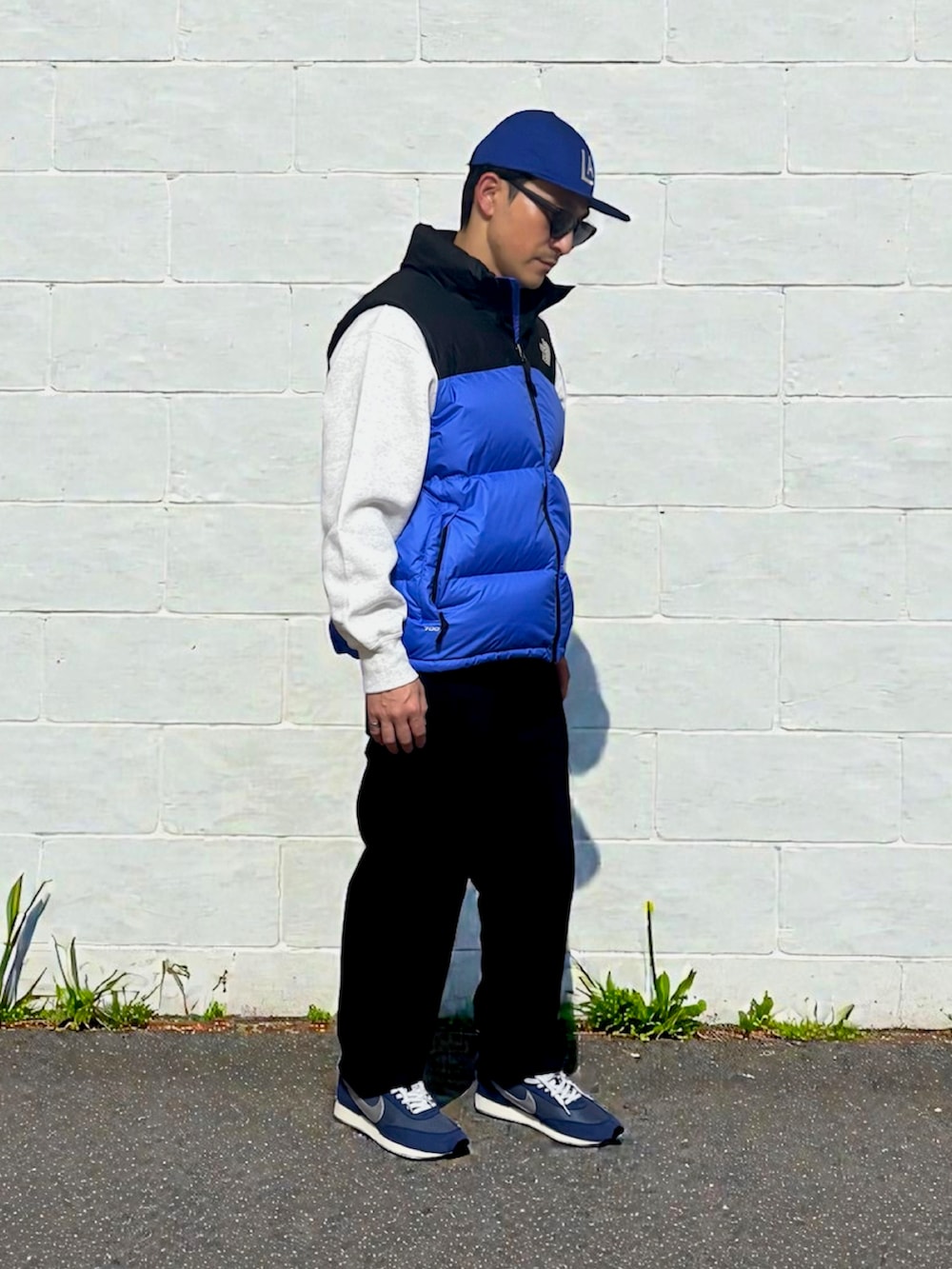 グレー系のスウェット、ブルー系のダウンベスト、グレー系のスウェットパンツを着用したメンズの冬コーディネートの3枚目の写真