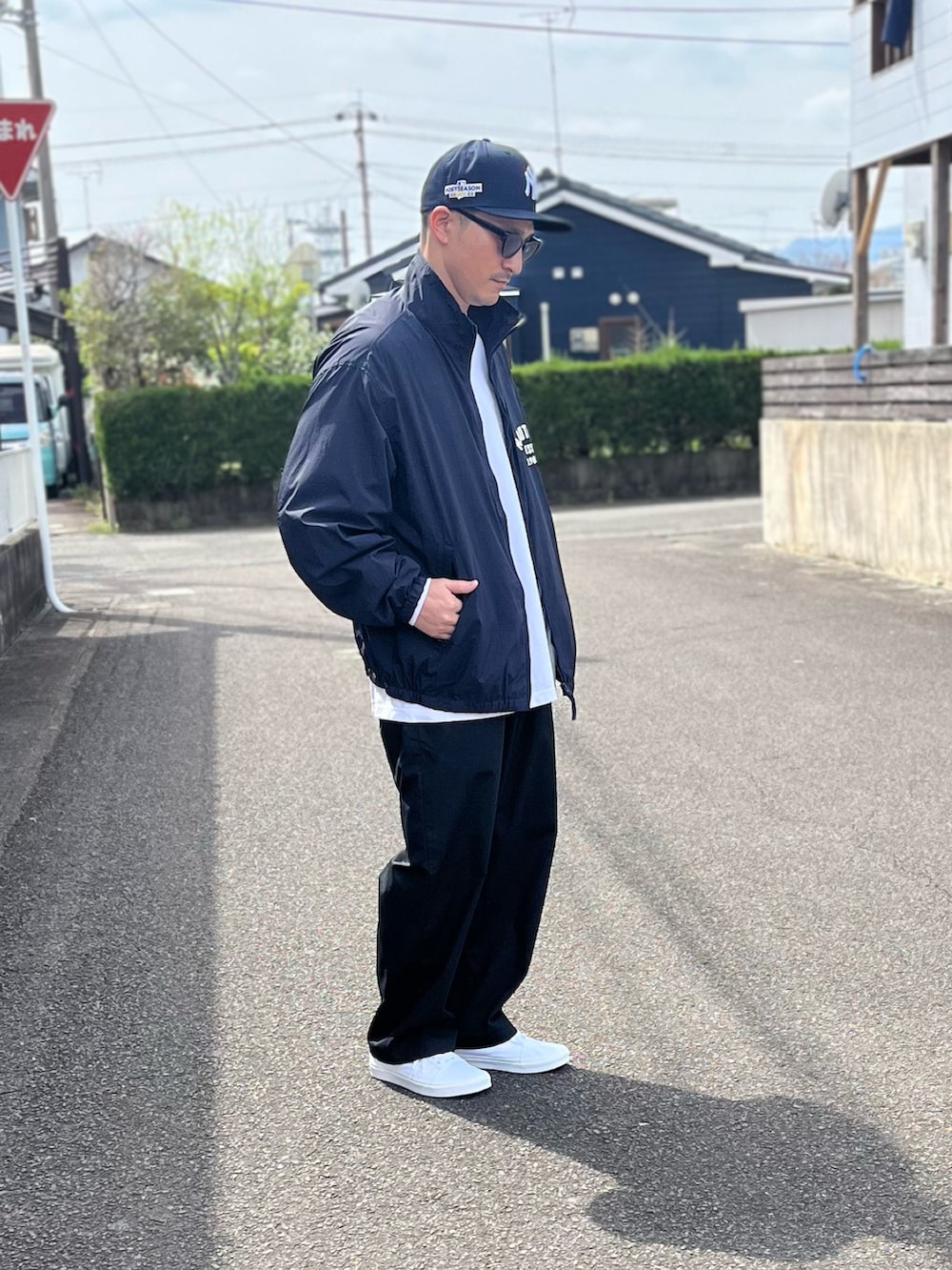 ブルー系のブルゾン、ホワイト系のTシャツ/カットソー、ブラック系のパンツを着用したメンズの春コーディネートの3枚目の写真