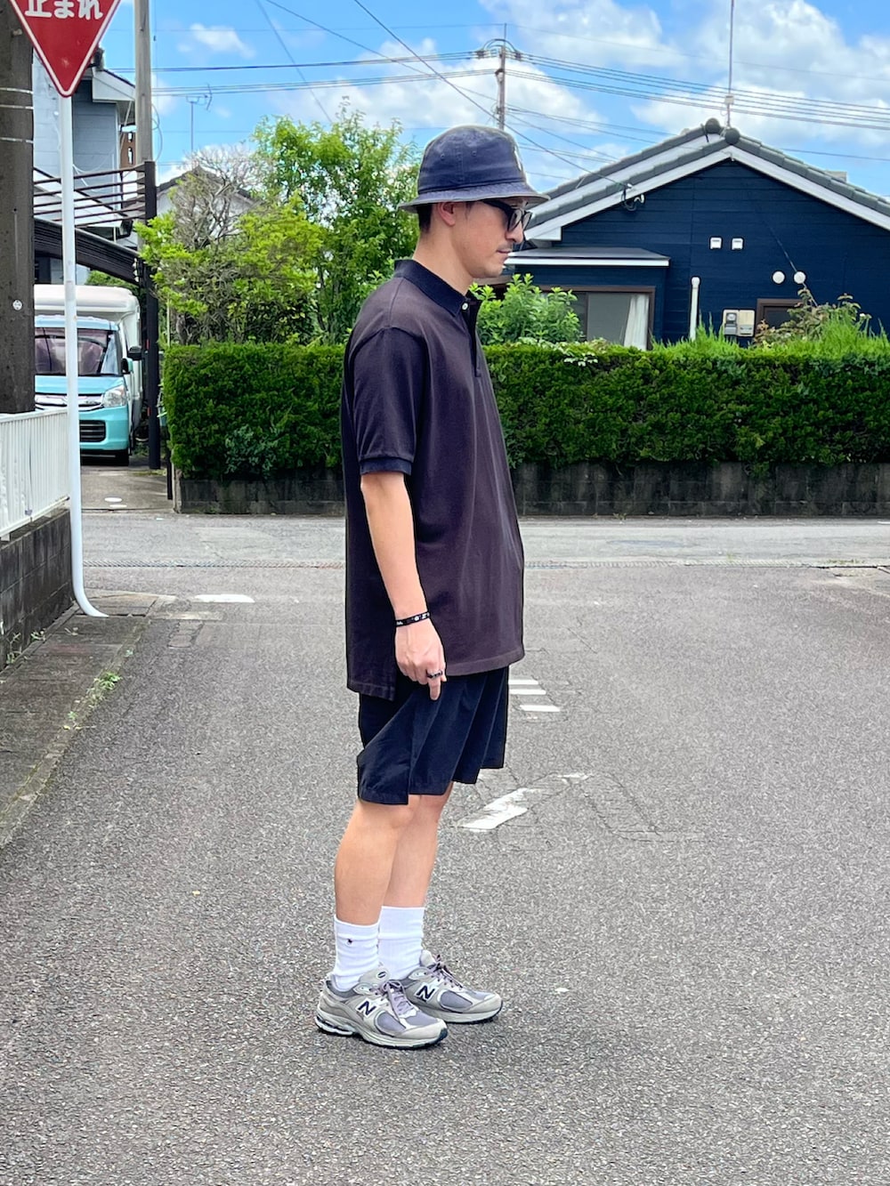 グレー系のスニーカー、ブラウン系のポロシャツ、ブルー系のその他パンツを着用したメンズの夏コーディネートの3枚目の写真