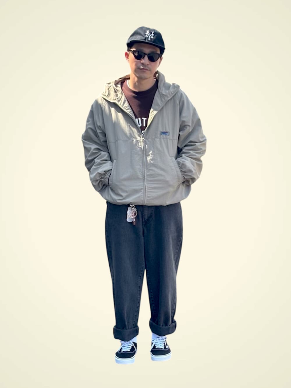 ブルー系のデニムパンツ、ブラック系のスニーカー、ブラウン系のスウェットを着用したメンズの春コーディネートの2枚目の写真