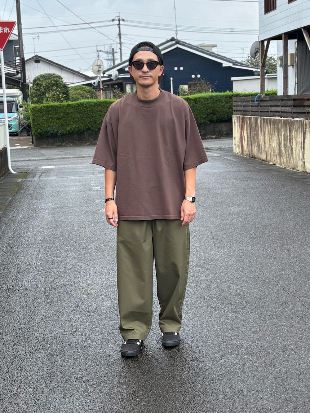 ブラック系のTシャツ/カットソー、グリーン系のチノパンツ、ブラック系のスニーカーを着用したメンズの秋コーディネートの2枚目の写真