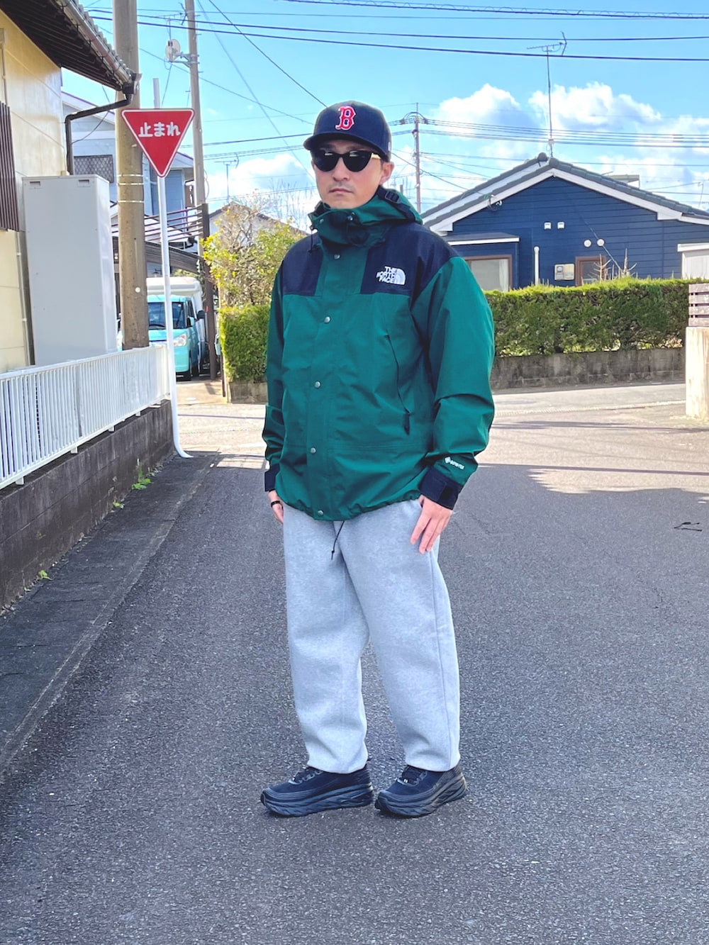 グリーン系のマウンテンパーカー、グレー系のスウェットパンツ、ブラック系のスニーカーを着用したメンズの冬コーディネートの3枚目の写真