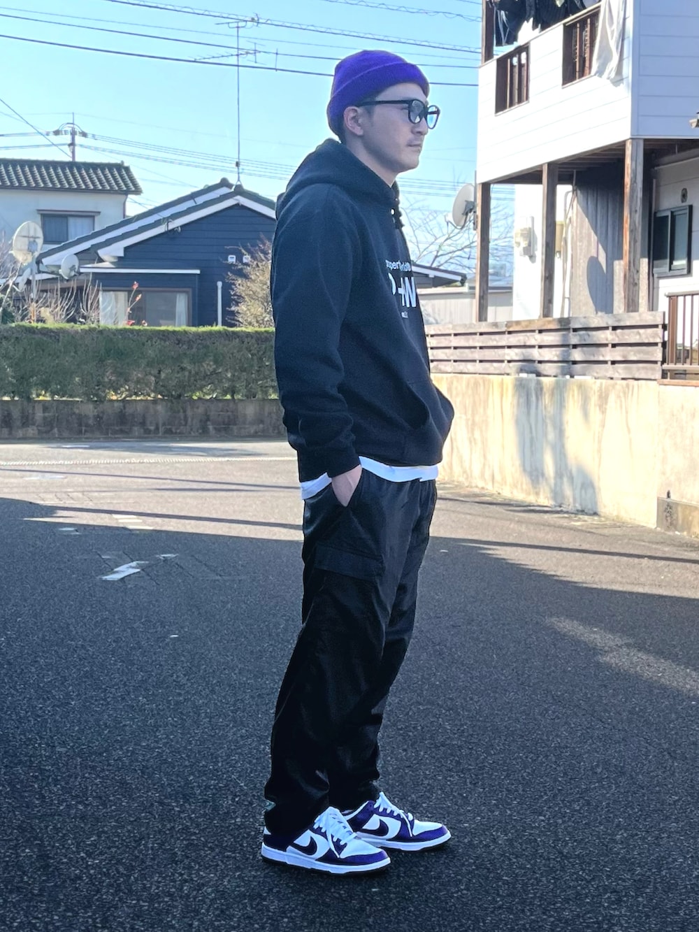 ホワイト系のTシャツ/カットソー、ブラック系のパンツ、パープル系のスニーカーを着用したメンズの冬コーディネートの3枚目の写真