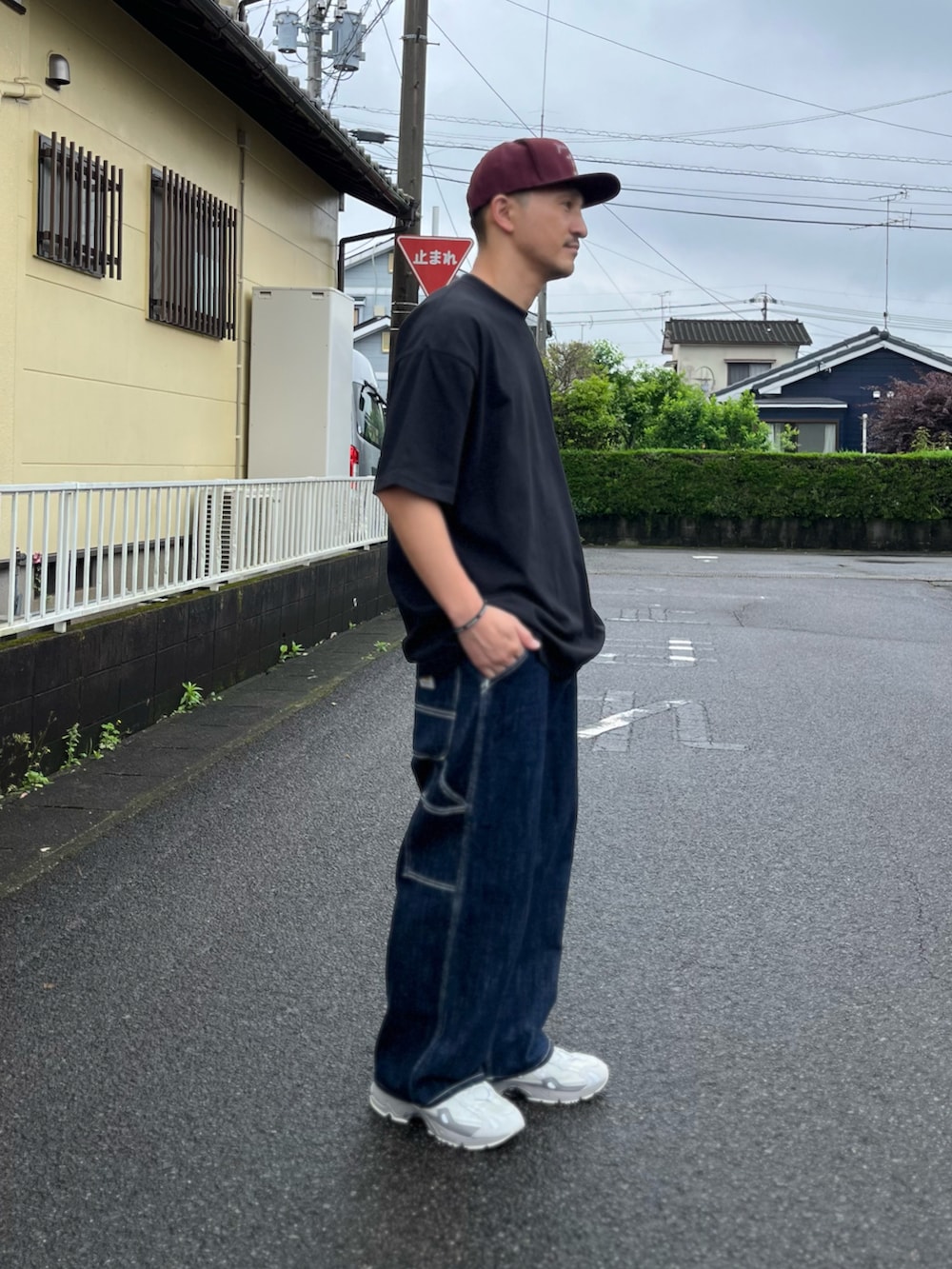 ブラック系のTシャツ/カットソー、ブルー系のデニムパンツ、グレー系のスニーカーを着用したメンズの春コーディネートの3枚目の写真