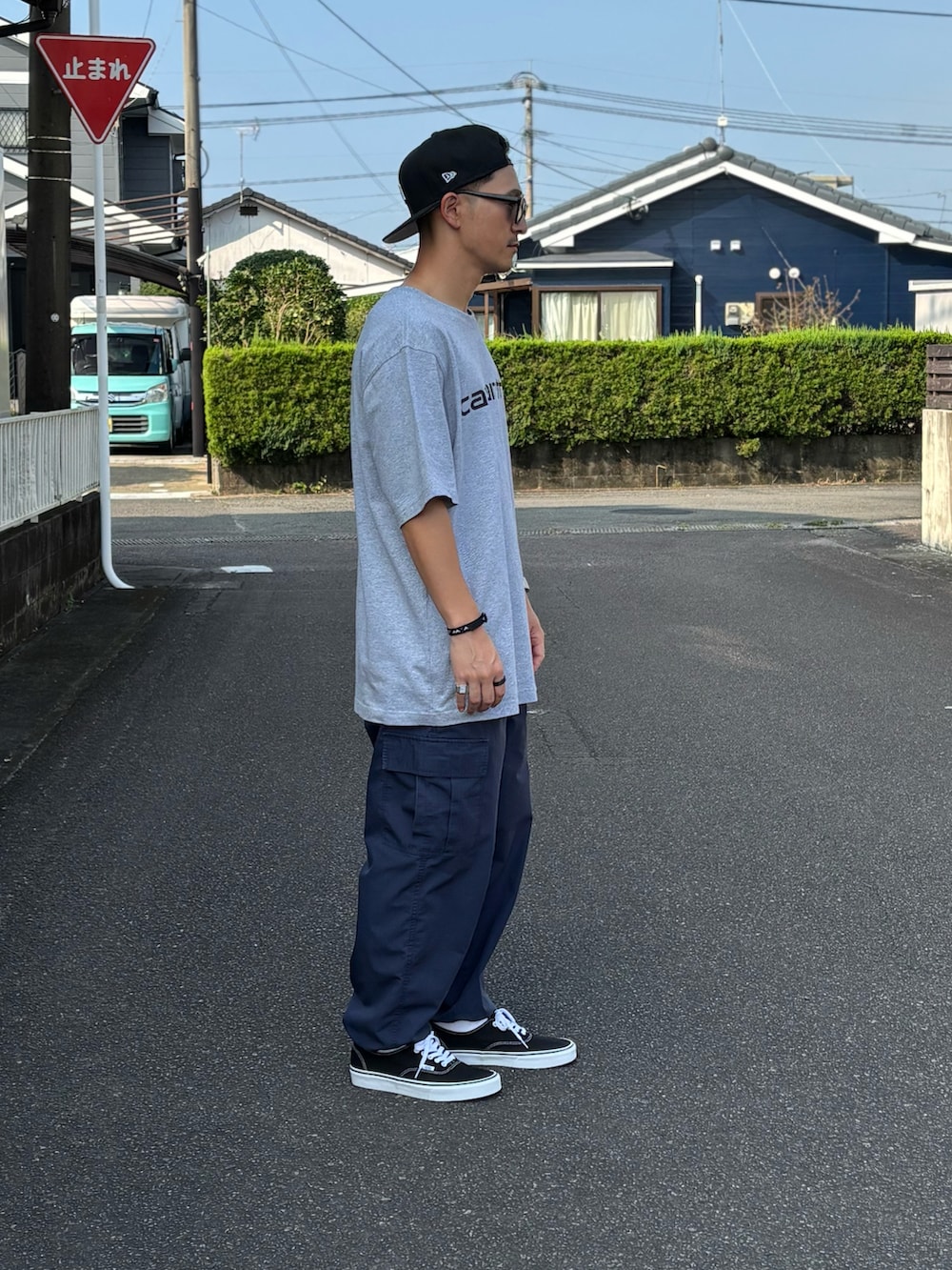 ブラック系のスニーカー、グレー系のTシャツ/カットソー、ベージュ系のカーゴパンツを着用したメンズの秋コーディネートの3枚目の写真