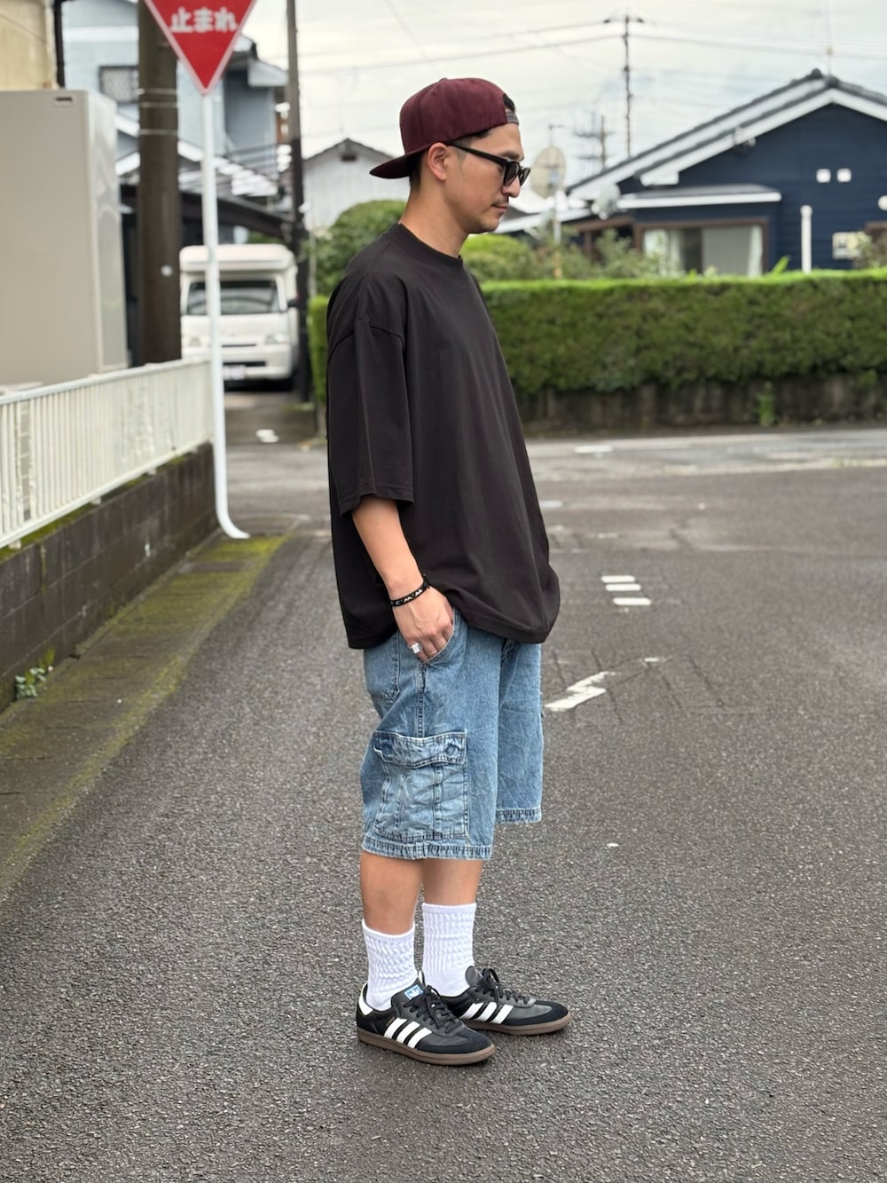 ブラック系のTシャツ/カットソー、ブラック系のスニーカー、ブルー系のデニムパンツを着用したメンズの夏コーディネートの2枚目の写真