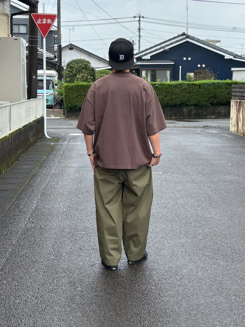 ブラック系のTシャツ/カットソー、グリーン系のチノパンツ、ブラック系のスニーカーを着用したメンズの秋コーディネートの4枚目の写真