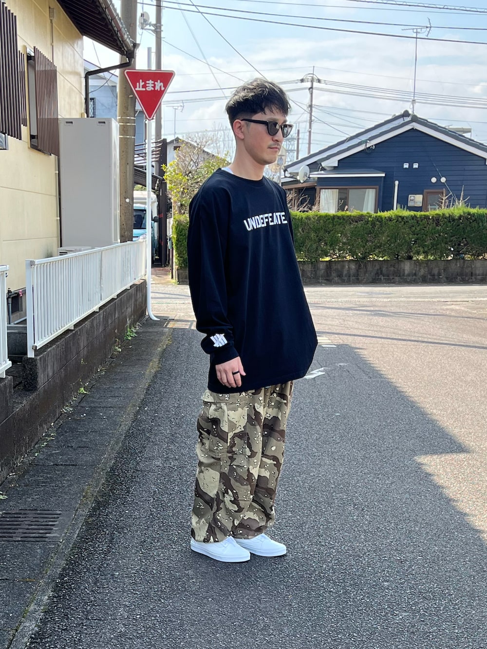 ブラック系のTシャツ/カットソー、ベージュ系のカーゴパンツ、ホワイト系のスニーカーを着用したメンズの春コーディネートの3枚目の写真