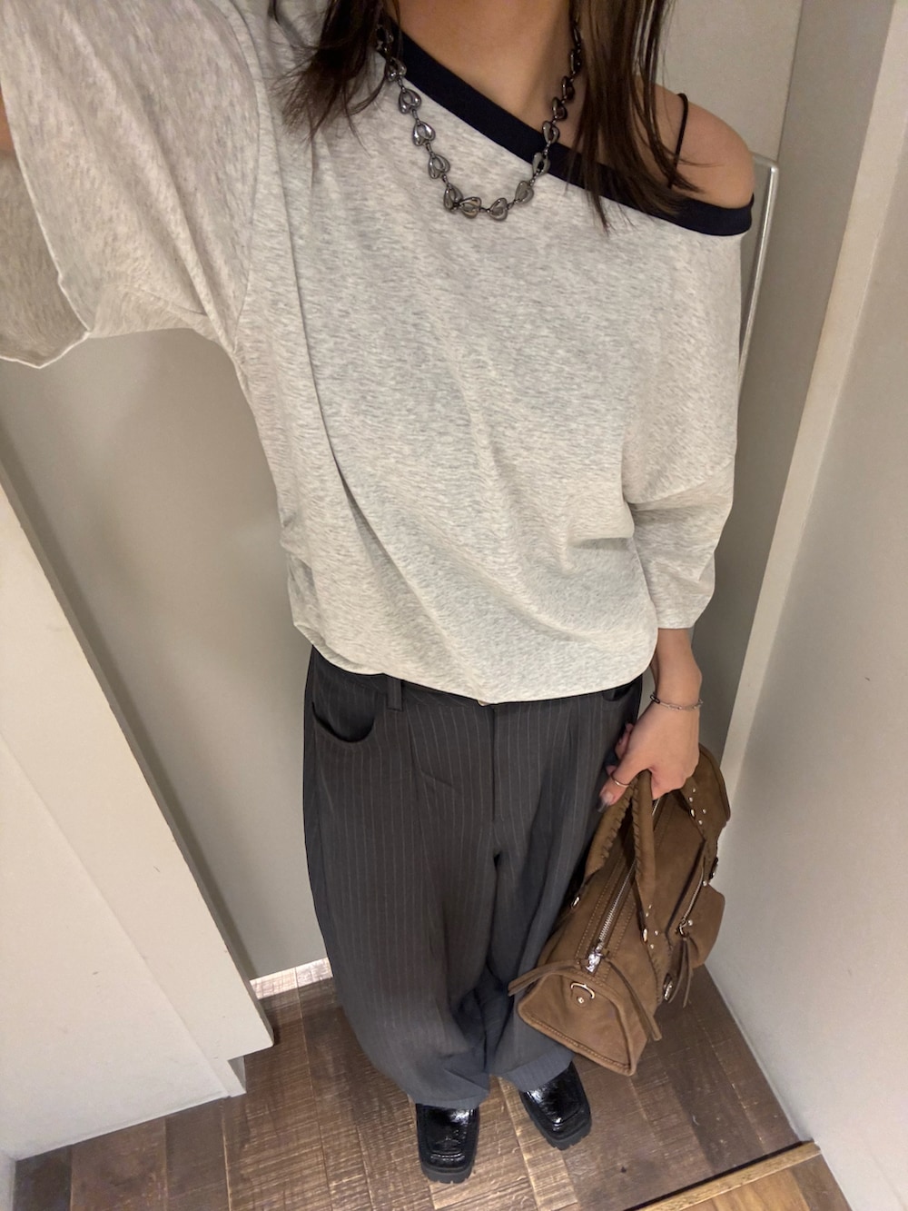 グレー系のTシャツ/カットソー、グレー系のスラックス、ブラック系のローファーを着用したレディースの夏コーディネートの4枚目の写真