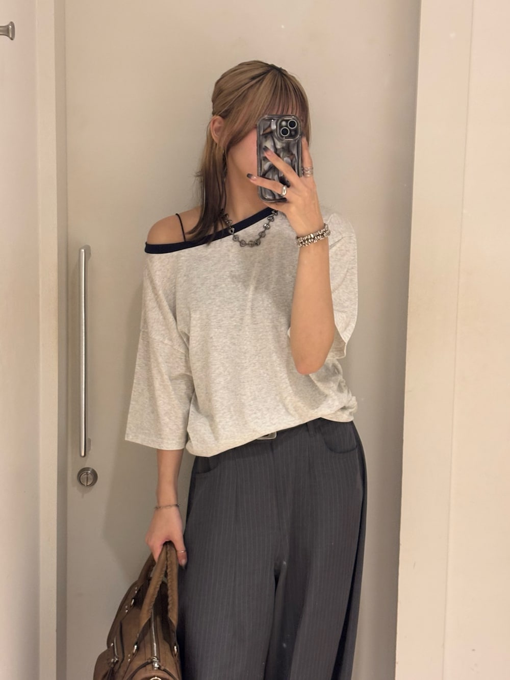 グレー系のTシャツ/カットソー、グレー系のスラックス、ブラック系のローファーを着用したレディースの夏コーディネートの3枚目の写真