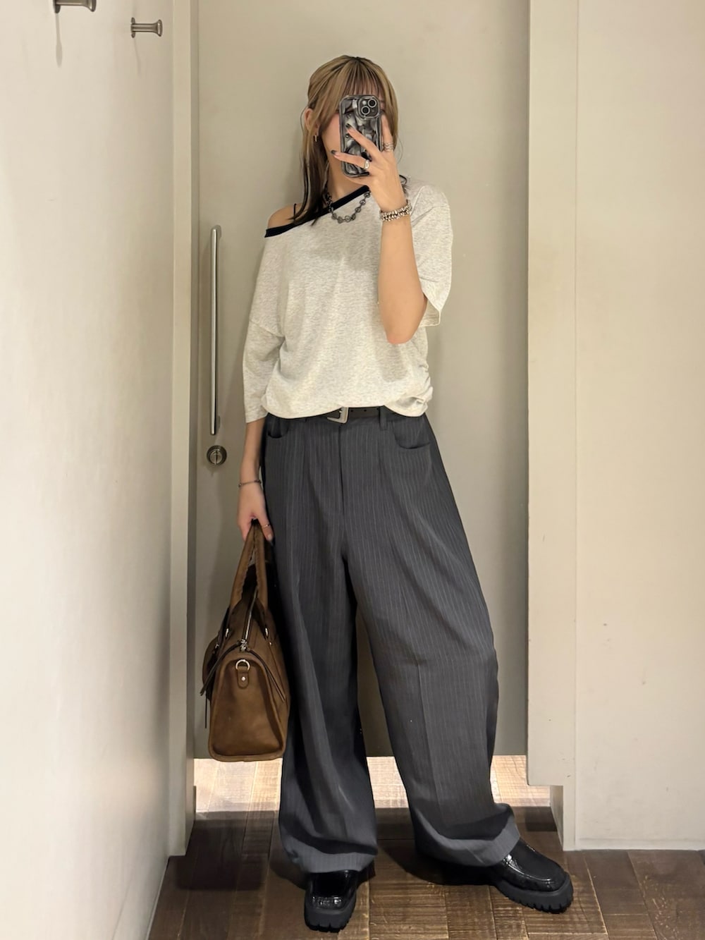グレー系のTシャツ/カットソー、グレー系のスラックス、ブラック系のローファーを着用したレディースの夏コーディネートの2枚目の写真