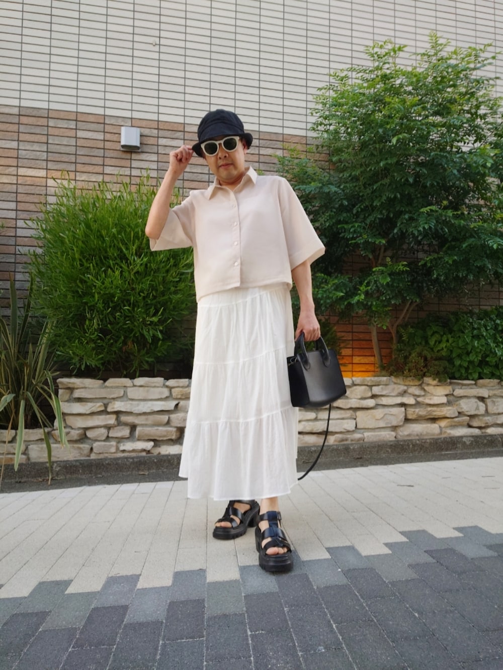 ホワイト系のスカート、ホワイト系のシャツ/ブラウス、ブラック系のサンダルを着用したメンズの夏コーディネートの2枚目の写真