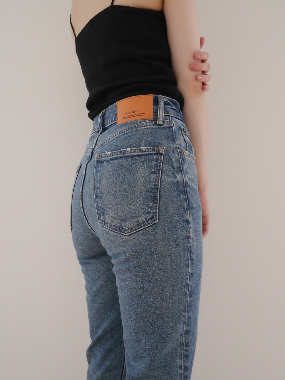 ブラック系のキャミソール、ブルー系のデニムパンツを着用したレディースの夏コーディネートの2枚目の写真