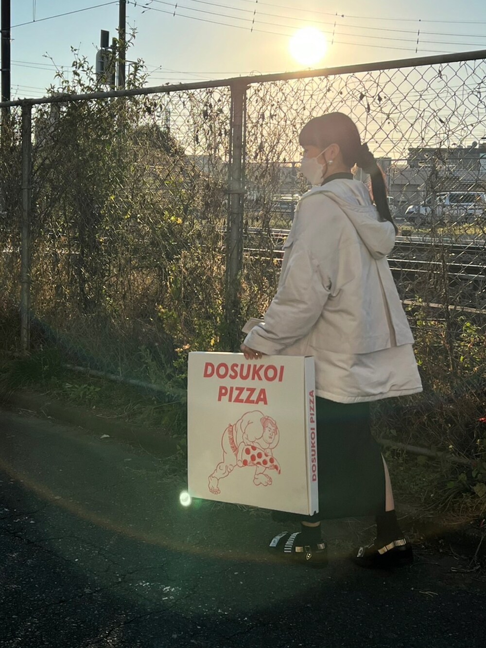 ホワイト系のジャケット/アウター、ブラック系のワンピース/ドレス、ブラック系のサンダルを着用したレディースの冬コーディネートの3枚目の写真