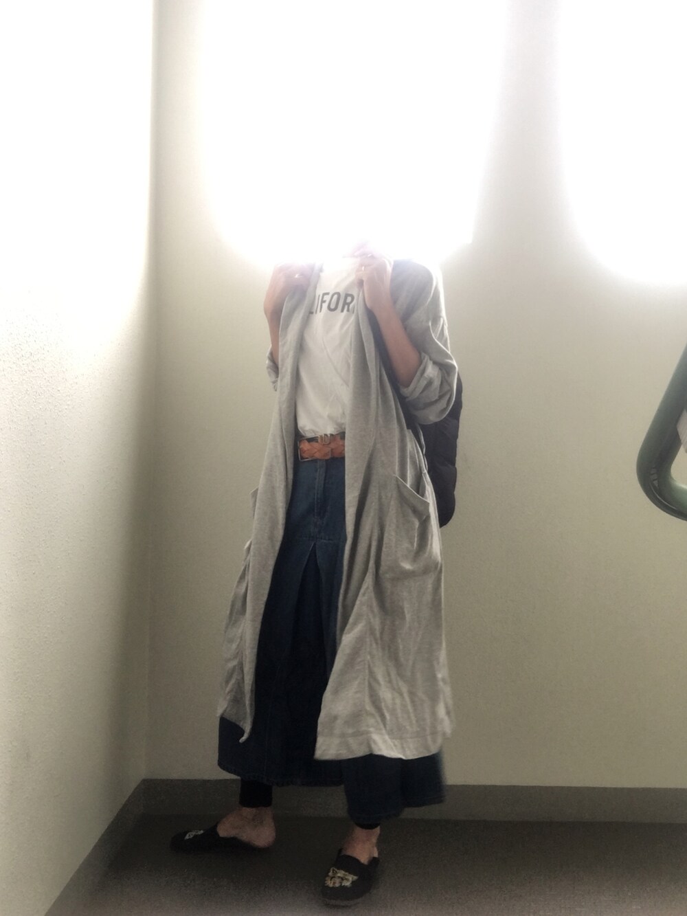 ブラック系のスリッポン、ブルー系のデニムパンツ、ホワイト系のTシャツ/カットソーを着用したレディースの秋コーディネートの2枚目の写真