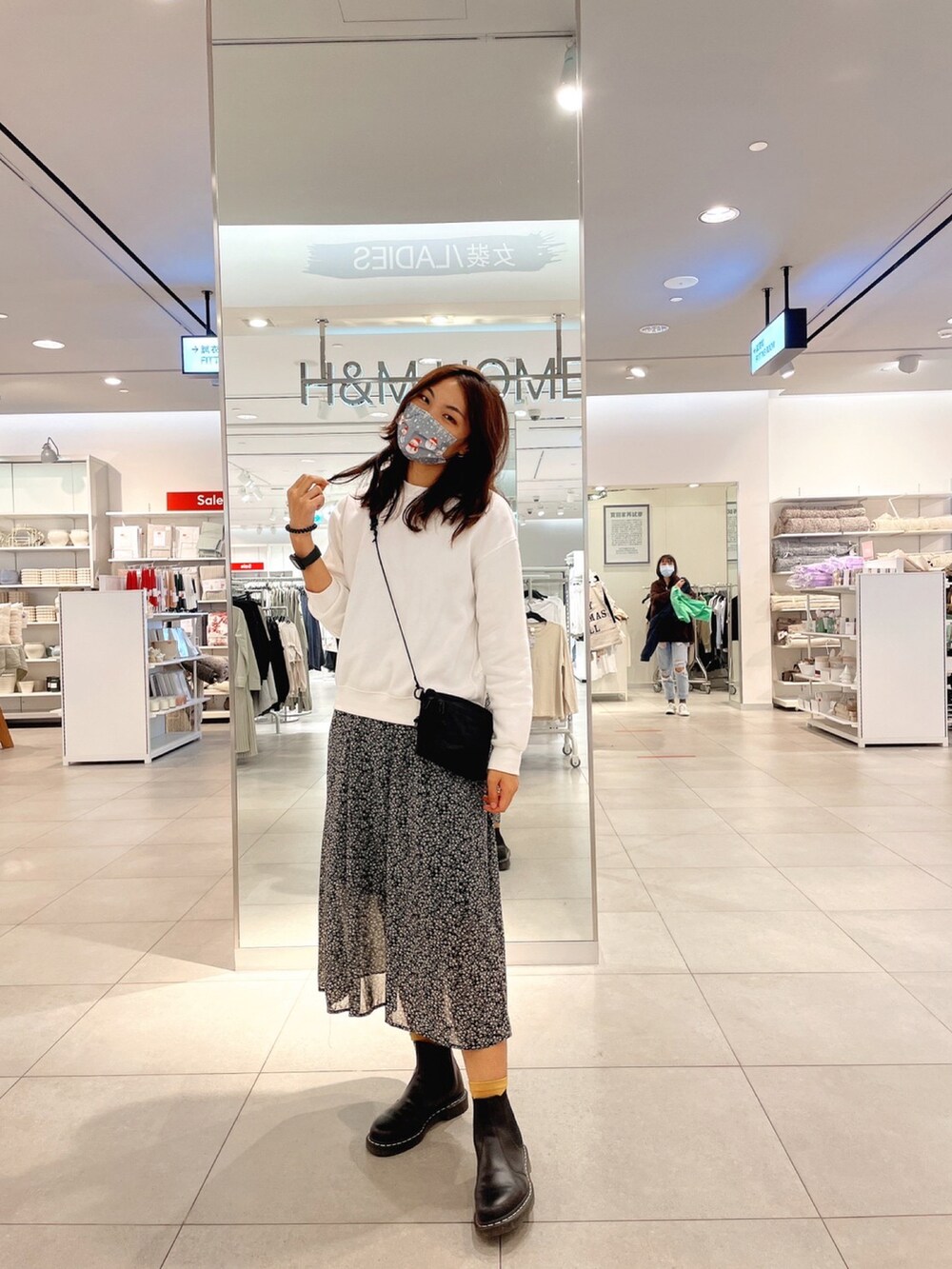 ホワイト系のパーカー、ブラック系のブーツを着用したレディースの冬コーディネートの3枚目の写真