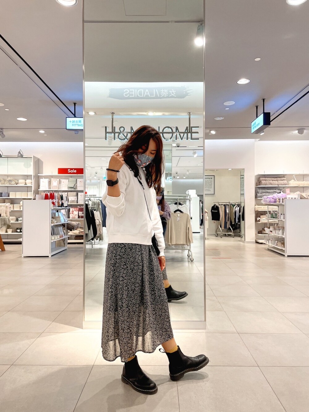 ホワイト系のパーカー、ブラック系のブーツを着用したレディースの冬コーディネートの2枚目の写真