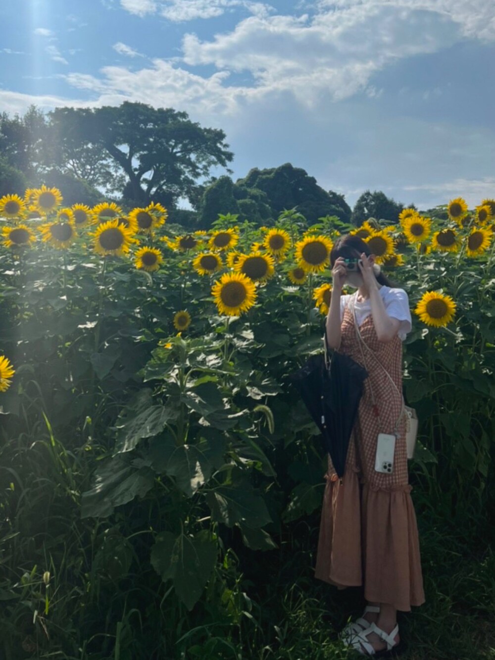 ブラウン系のワンピース、ホワイト系のサンダルを着用したレディースの夏コーディネートの2枚目の写真