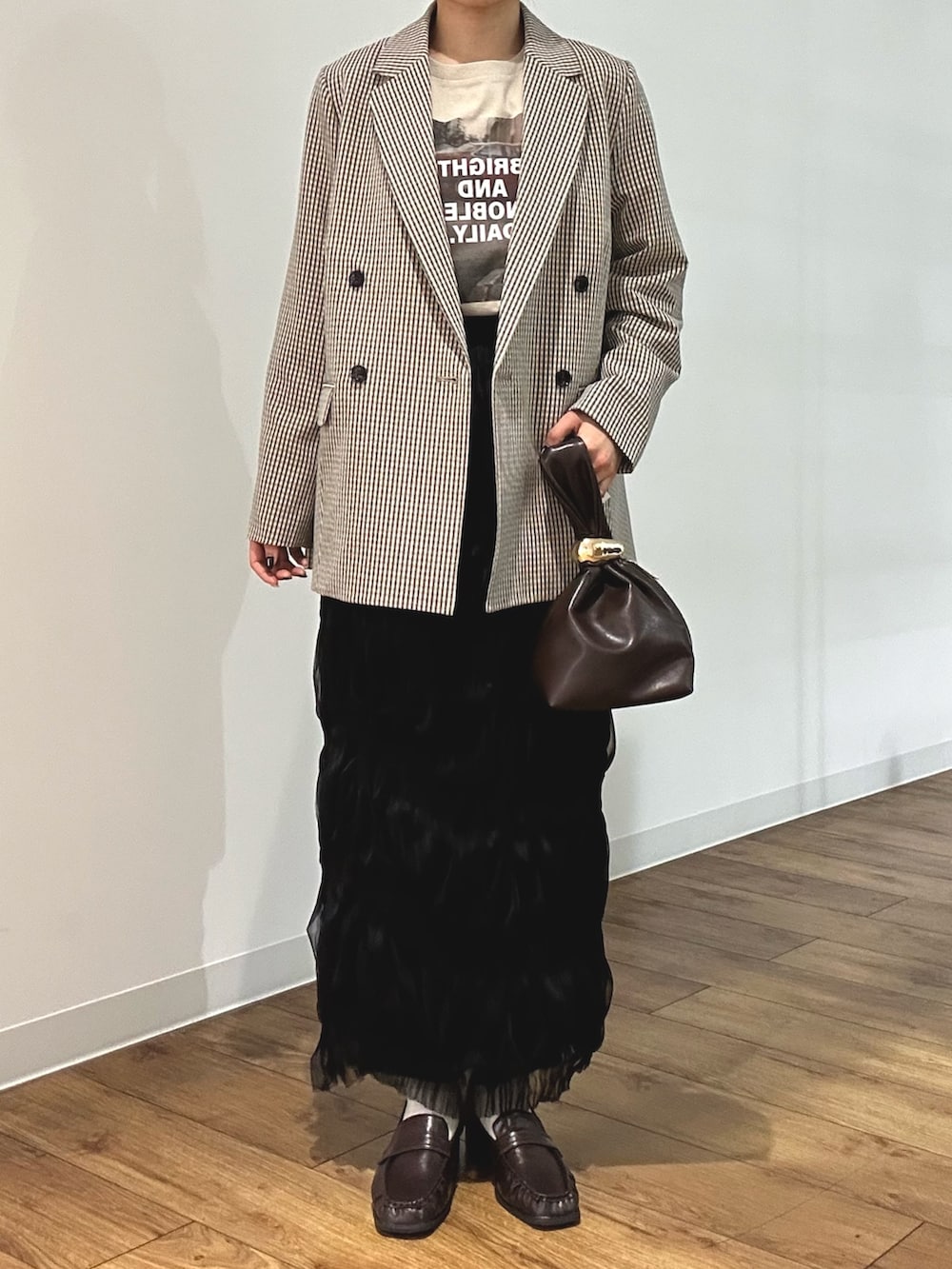 ベージュ系のテーラードジャケット、その他のTシャツ/カットソー、ブラウン系のハンドバッグを着用したレディースの冬コーディネートの3枚目の写真