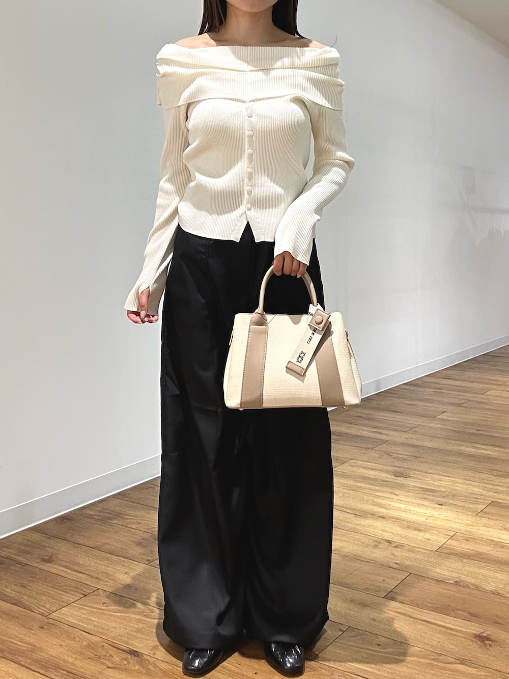 ホワイト系のニット/セーター、ブラック系のその他パンツ、ブラック系のパンプスを着用したレディースの春コーディネートの3枚目の写真