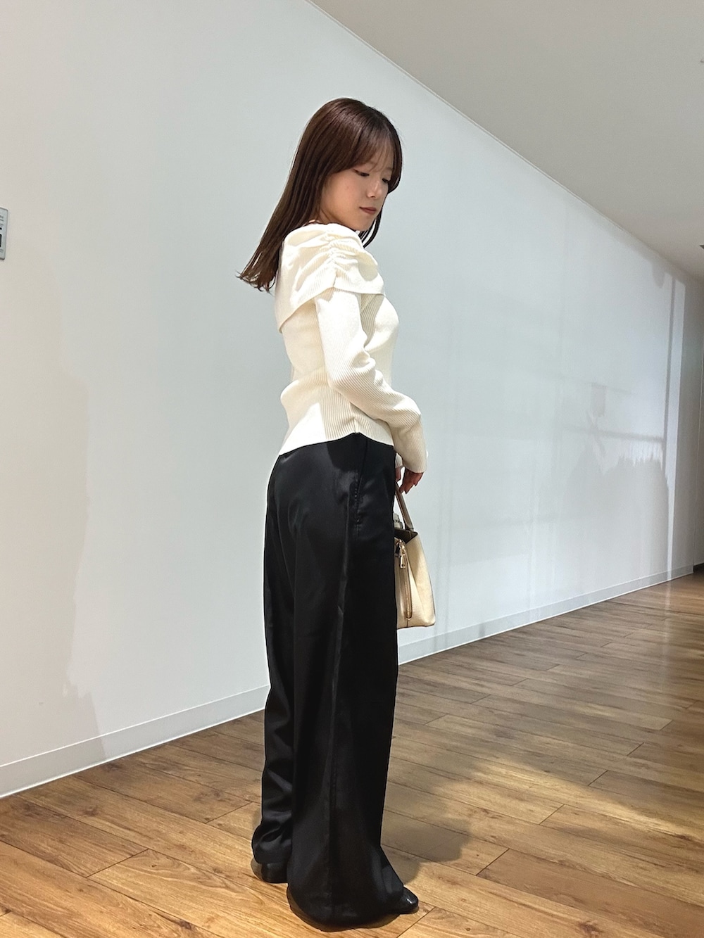 ホワイト系のニット/セーター、ブラック系のその他パンツ、ブラック系のパンプスを着用したレディースの春コーディネートの2枚目の写真