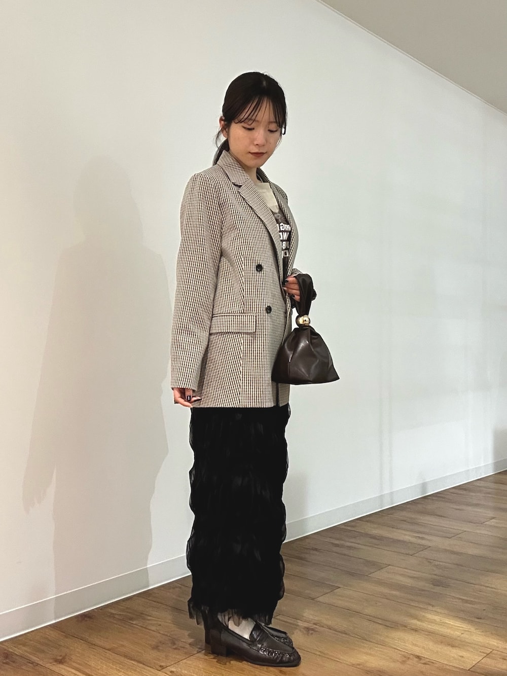 ベージュ系のテーラードジャケット、その他のTシャツ/カットソー、ブラウン系のハンドバッグを着用したレディースの冬コーディネートの2枚目の写真