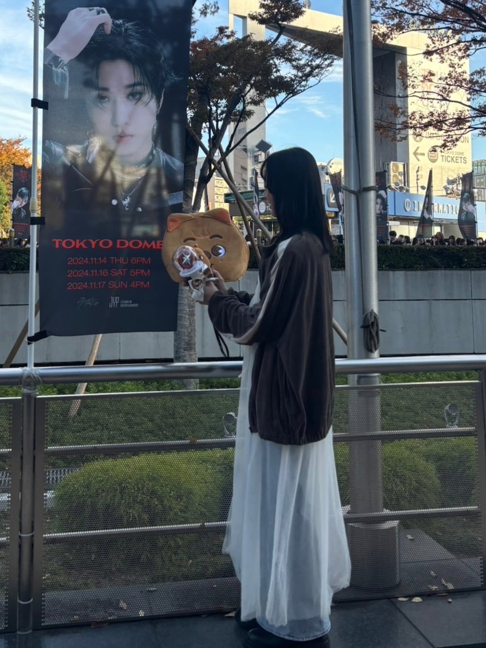 ホワイト系のワンピース、ブラウン系のブルゾン、ブルー系のデニムパンツを着用したレディースの冬コーディネートの2枚目の写真